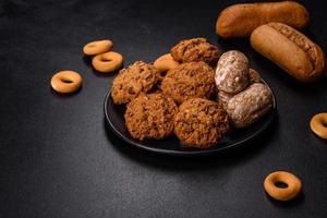 Tasty fresh oat cookies on a dark concrete background photo