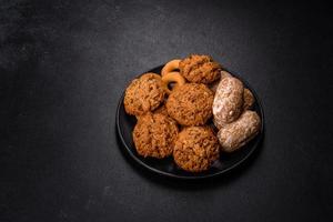 Tasty fresh oat cookies on a dark concrete background photo