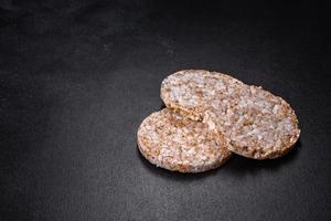 Three round crunchy buckwheat crispbread on a dark concrete background