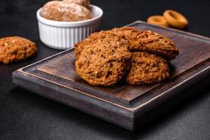 Tasty fresh oat cookies on a dark concrete background photo