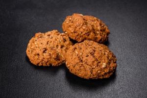 Tasty fresh oat cookies on a dark concrete background photo