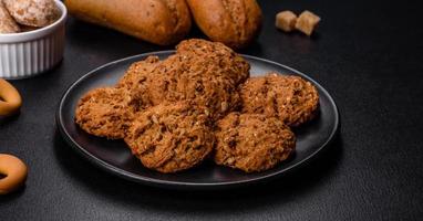 Tasty fresh oat cookies on a dark concrete background photo