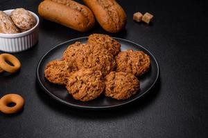 Tasty fresh oat cookies on a dark concrete background photo