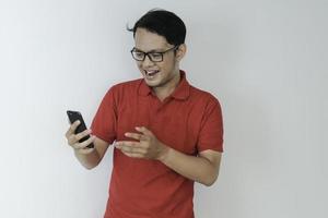 Smart Young asian man is happy and smiling when using smartphone in studio background photo