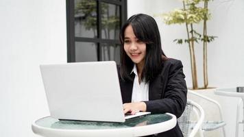 mujer de negocios joven asiática que trabaja en la computadora en la oficina foto