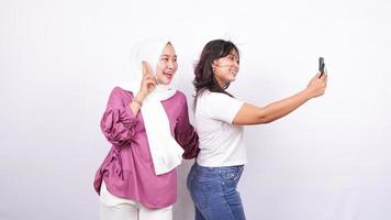 two asian women doing selfies isolated white background photo