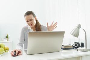 Girl listens or looks at information on computer with disbelief. Skeptical expression. Fake news. photo