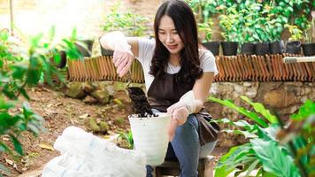 mujer asiática prepara un lugar para plantar con maceta foto