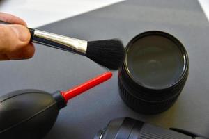 Cleaning photo lenses with a brush and a pear