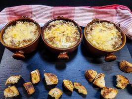 Fresh French onion soup with coutons and cheese topping photo