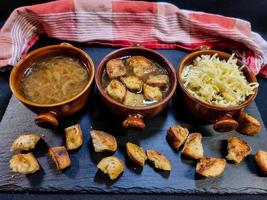 Fresh French onion soup with coutons and cheese topping photo