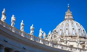 Decoration of statues on Saint Peter Cathedral with the Cupola in background - Rome, Italy photo