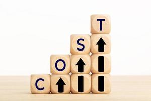 Cost growth concept. Text and Arrow icon on wooden blocks. Copy space photo