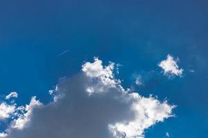 Blue sky background with clouds and rays. Sun light rays or beams bursting from the clouds on a blue sky. Spiritual religious background. photo