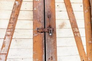 Old rusty padlock on a wooden door photo