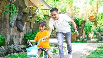 padre e hija practicando bicicletas en el parque foto