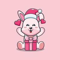 lindo conejito feliz con regalo de navidad. linda ilustración de dibujos animados de navidad. vector