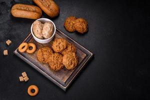 Tasty fresh oat cookies on a dark concrete background photo