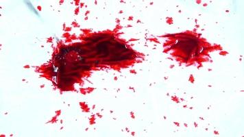 rote tintentröpfchen auf nassem papiermaterial. video