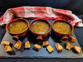 Fresh French onion soup with coutons and cheese topping photo