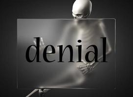 denial word on glass and skeleton photo