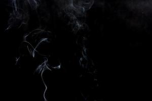 Abstract smoke swirls on black background photo