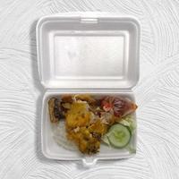 Lunch of rice with fried chicken called ayam penyet on a styrofoam container photo