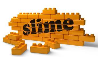 slime word on yellow brick wall photo