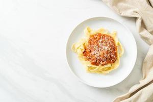 pork bolognese fettuccine pasta with parmesan cheese photo