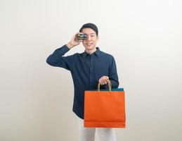 portrait young Asian man holding credit card and shopping bag photo