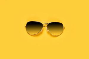 Classic sunglasses on bright yellow background photo