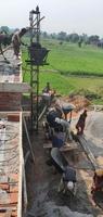 sialkot, pakistán - 2022, un grupo de trabajadores no identificados que trabajan en un sitio de construcción en sialkot al aire libre, pakistán foto