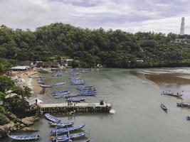 Aerial view of Baron beach in Yogyakarta, Indonesia with lighthouse and traditional boats photo