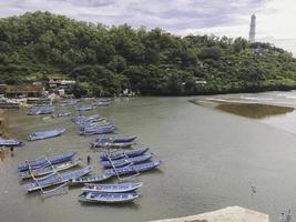 Aerial view of Baron beach in Yogyakarta, Indonesia with lighthouse and traditional boats photo