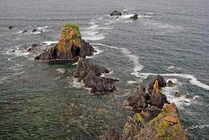 rocas irregulares en la costa del océano foto