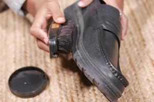 cleaning Shoe with a brush on floor photo