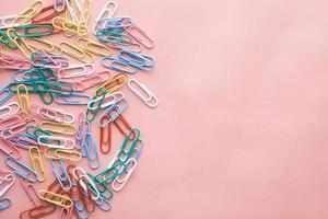colorful paper clip dropping on pink background . photo
