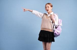 Young Asian high school girl on blue background photo