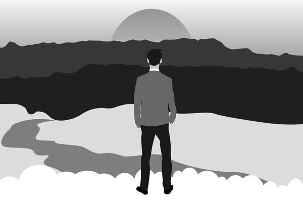 Silhouette of a businessman reaching the top of the mountain