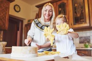 Happy daughter and mom in the kitchen bake cookies photo