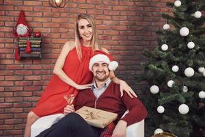 pareja joven encuentro navidad abrazando a casa. Año nuevo. estado de ánimo festivo de un hombre y una mujer foto