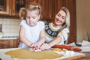 Happy daughter and mom in the kitchen bake cookies photo