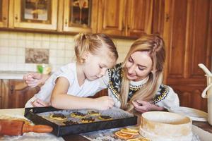 Mom and daughter are busy baking cookies photo