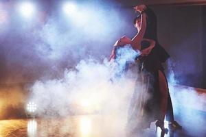 hábiles bailarines actuando en la habitación oscura bajo la luz y el humo del concierto. pareja sensual realizando una danza contemporánea artística y emocional foto