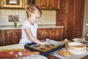 mamá e hija están ocupadas horneando galletas foto