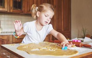 feliz hija y mamá en la cocina hornean galletas foto