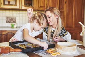 Mom and daughter are busy baking cookies photo