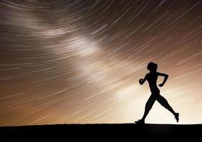 una chica deportiva al amanecer se dedica al yoga. clases de gimnasia en el cielo estrellado foto