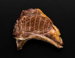a piece of fresh grilled meat on black background