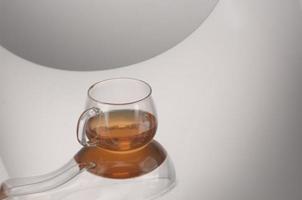 Transparent glass teapot and cup with tea photo